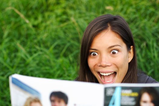 Excited woman surprised by gossips she is reading in magazine.
