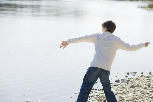 Young Boy Throwing Stones in a River