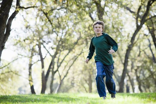 Young Boy Running in The Grass in a Park