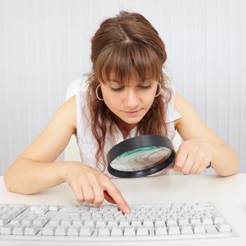 The girl with a poor eyesight works with the computer keyboard