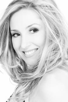 Portrait of a smiling woman with tousled hair  in black and white tones.