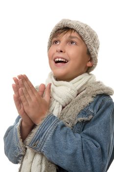 Young boy dressed in winter clothing looking up and smiling