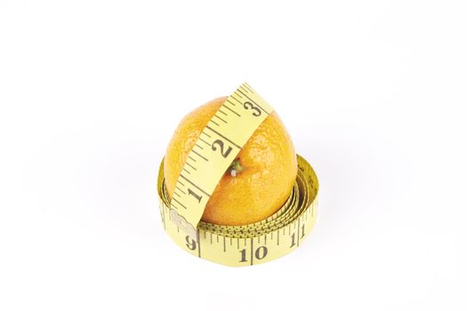 Small single satsuma with tape measure wrapped around on a reflective white background