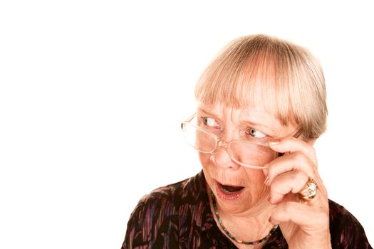 Shocked senior woman looking sideways over the top of her glasses