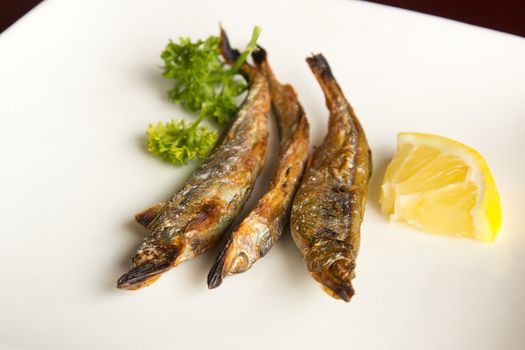 Japanese style grilled fish in a white plate with lemon