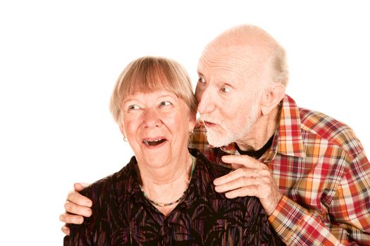 Happy senior couple pointing and looking left