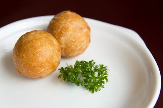 Deep fried yam balls served in a white plate