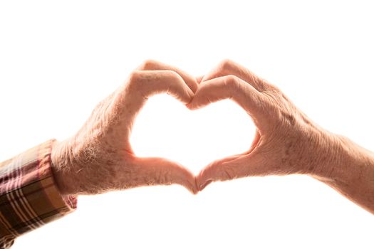 Senior couple forming heart by touching hands together