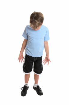 Boy standing in plain blue t-shirt and shorts looking down.  Focus to head.