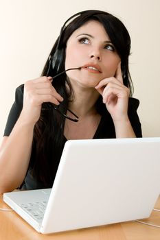 A woman at laptop computer thinking.