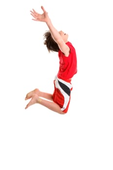 A happy boy leaps mid jump with hands stretched towards the sky.