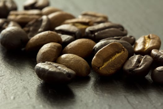 Brown and black coffee beans on dark background