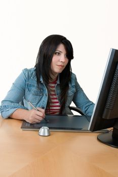 A female worker at computer with graphic tablet.