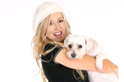 Smiling woman carrying a small dog in her arms.