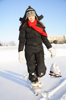 Ice skating. Woman walking with figure skating ice skates outdoors in the snow in Quebec, Canada.