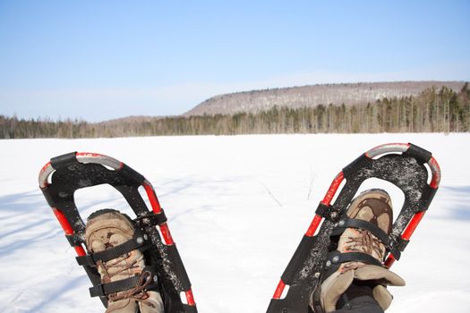 Snowshoes from a winter hike by a frozen lake in Quebec, Canada.