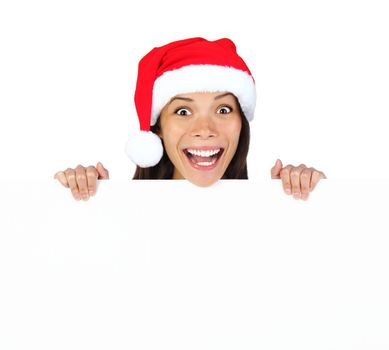 Christmas woman with billboard sign. Very beautiful mixed race asian / caucasian woman standing behind billboard looking happy and surprised at camera with funny expression. Isolated on white background.