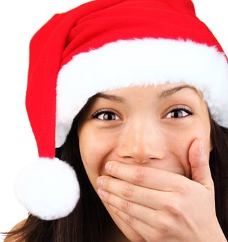 Christmas girl very excited and surprised holding her mouth. Beautiful mixed asian / caucasian model. 