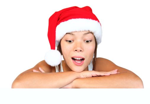 Christmas girl with sign. Very beautiful mixed race asian / caucasian woman with billboard looking surprised down at the sign. Isolated on white background.