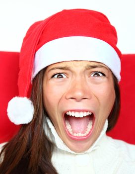 Screaming christmas woman with santa hat. Beautiful mixed asian / caucasian model. 