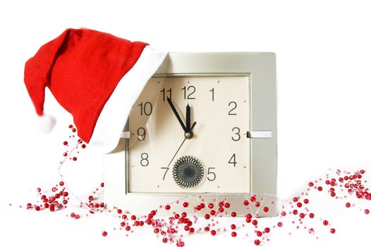 Santa cap on clock and Christmas decoration over white