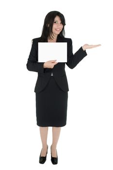 Standing woman in suit holds a sign and hand extended for product.