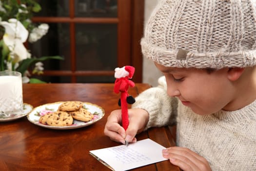 A child writes out his Christmas wishlist for Santa on Christmas Eve.