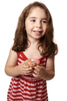 Smiling girl wearing a red striped dress is holding an iced pink doughnut.