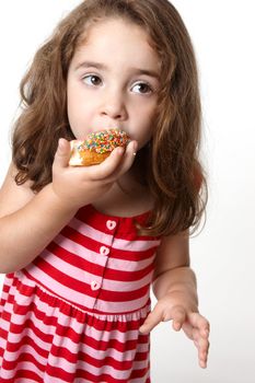 Little girl in a light pink and red striped dress eats a tasty pink iced decorated doughnut 