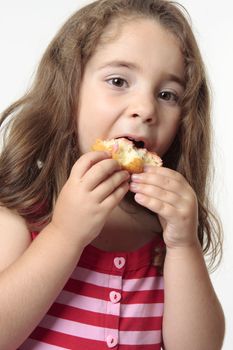 Young child talking a big bite from a doughnut.