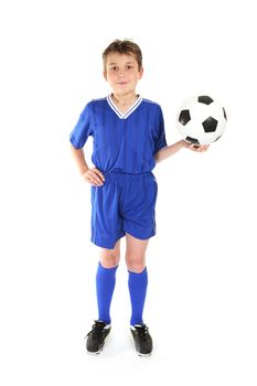Boy standing with hand on hip and holding a soccer ball in the other hand