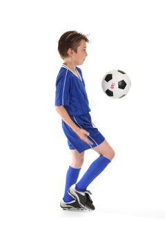 A boy in training, practices some soccer moves.  Motion in bent leg and arm