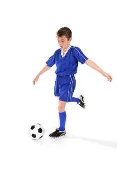 A boy kicks a soccer ball. Some slight motion