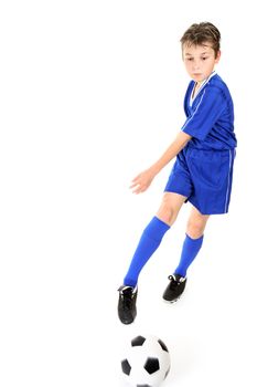 Child kicking or manoeuvring a soccer ball.  Motion to ball and kicking foot.