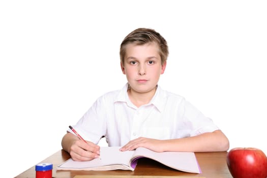 School student sitting at desk with book and pencil doing work.