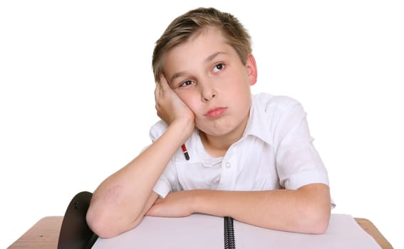 A school student with head resting on one hand, siting in front of an empty book,  lost in thought, daydreaming, or thinking about what to write