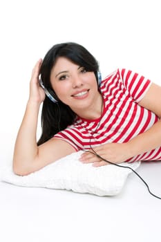 Female lying down and listening to music through headphones.