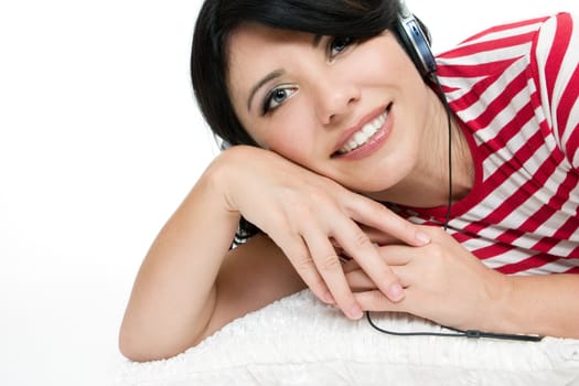 Casual dressed woman relaxing on cushion and listening to music.