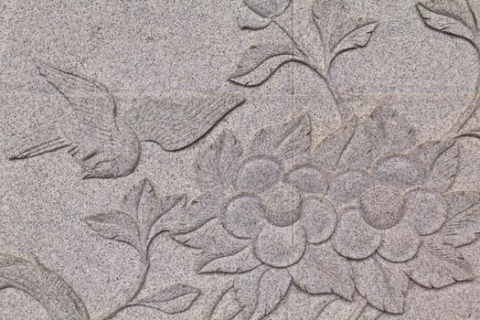 Bird carved on stone wall in chinese temple Thailand