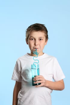 Thirsty child drinking pure fresh water from a tall glass