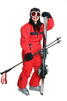 Female skier wearing a red ski suit and carryng matching skis and poles.