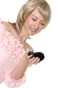 An adult woman checks her makeup in a handheld mirror