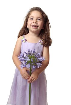 Smiling girl looking up holding a purple agapanthus flower.  Space for your copy.