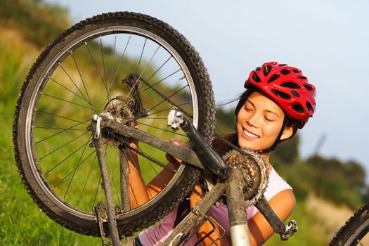 Bike repair. Woman repairing mountain bike. Beautiful smiling woman.