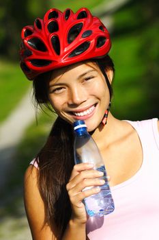 Excercise woman. Beautiful young woman enjoying a bottle of water outdoors during a bike trip