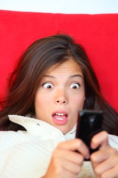 Surprised woman reading shocking sms text message. 