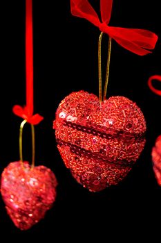Christmas red hearts hanging isolated on black