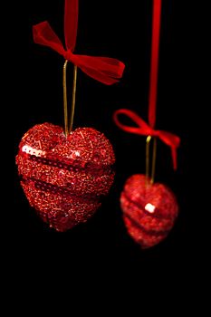 Christmas red hearts hanging isolated on black
