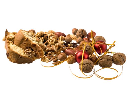 Pieces of christmas cake, nuts, and xmas decoration isolated against white.