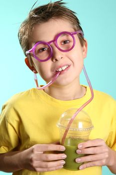 A boy drinks a healthy juice containing wheatgrass, barleygrass and spirulina. Spirulina is a better source of protein than soyabeans and is best known for its ability to boost the immune system, it stimulates the natural killer (NK) cells that fight illness and attack and kill cancerous cells.